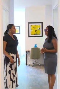 two women standing in a hallway talking to each other